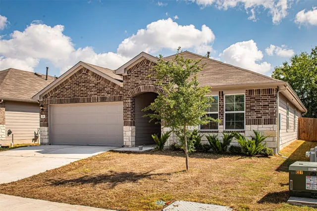 a view of a house with a yard and potted plants