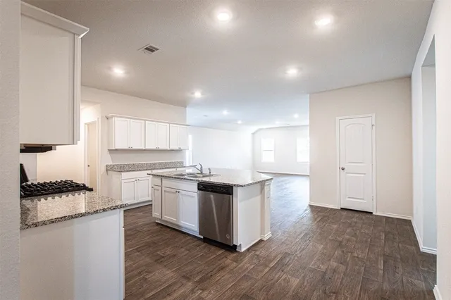 a kitchen with stainless steel appliances kitchen island granite countertop a stove a sink and a refrigerator