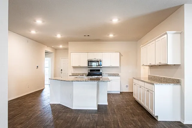 a kitchen with stainless steel appliances granite countertop a stove a sink and a refrigerator