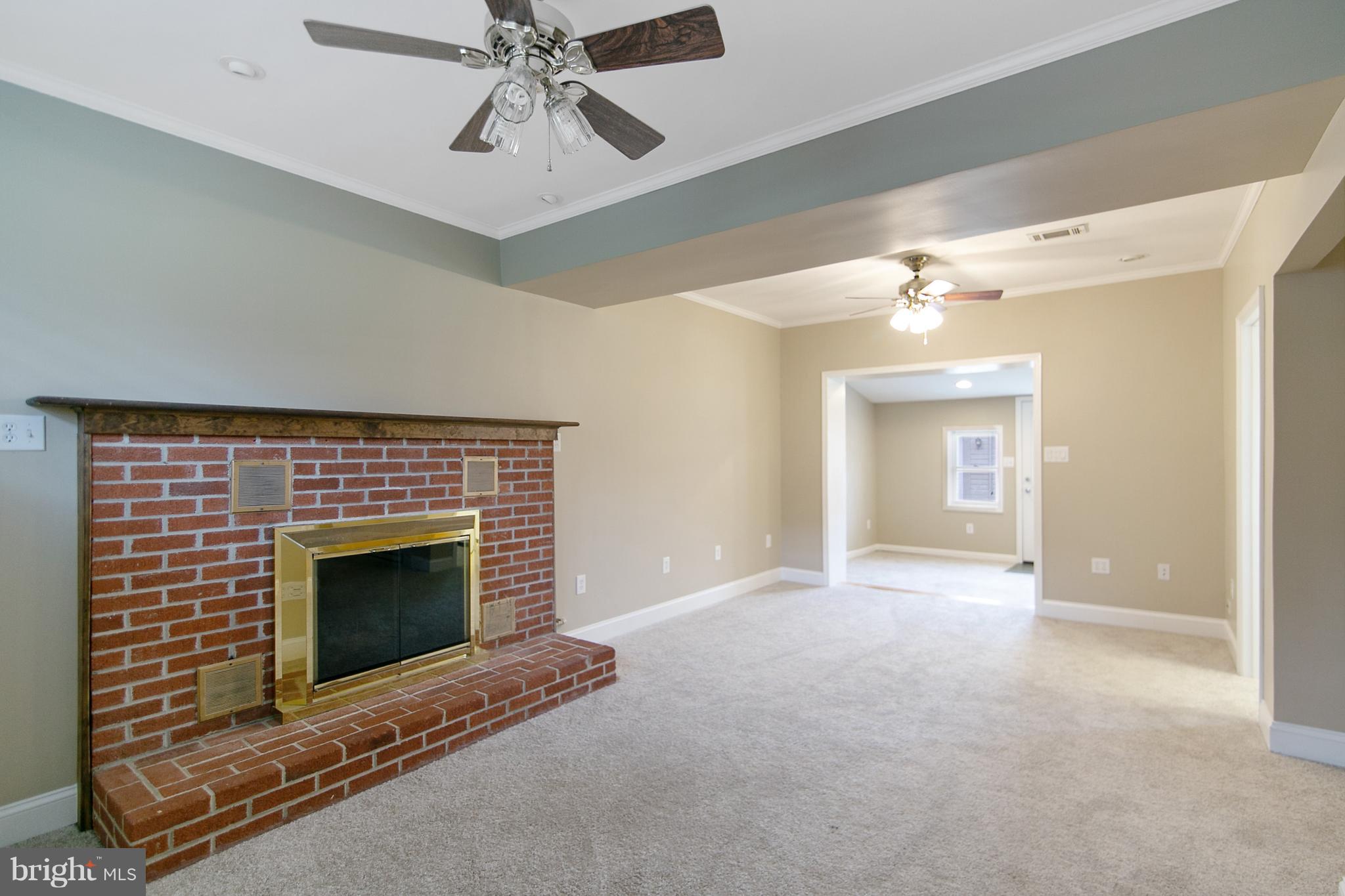 8306 Hollow Road Middletown, MD 21769 - Photo 13 of 37 a view of an empty room with chandelier fan and fire place