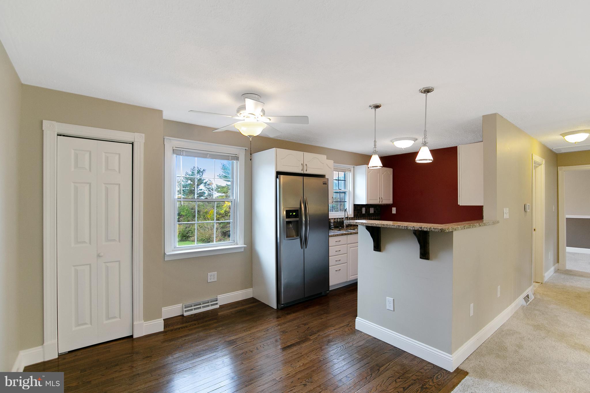 8306 Hollow Road Middletown, MD 21769 - Photo 5 of 37 a view of a kitchen with a fridge wooden floor and a window