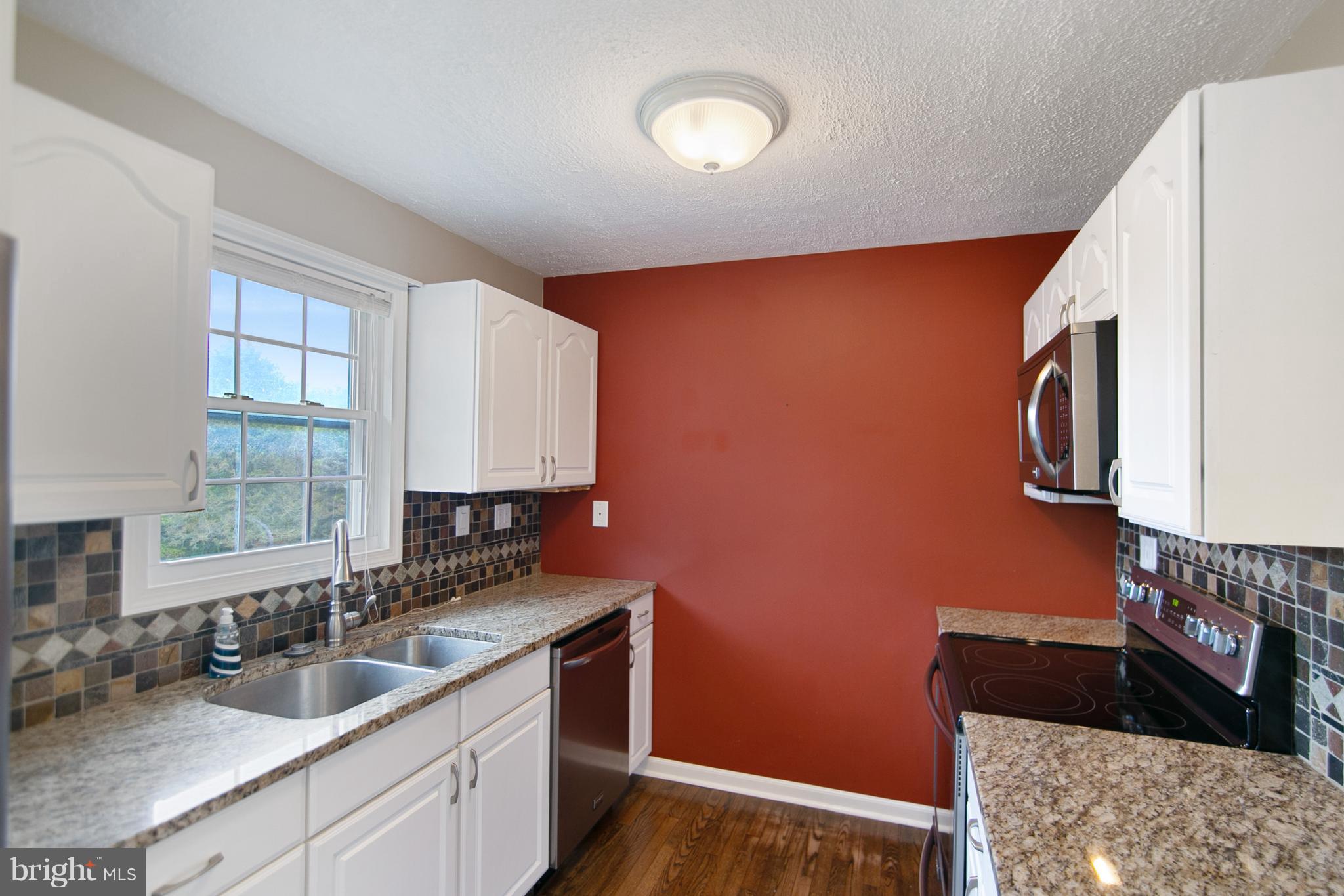 8306 Hollow Road Middletown, MD 21769 - Photo 9 of 37 a kitchen with sink a stove and a wooden floor