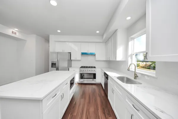 a kitchen with a sink a counter top space stainless steel appliances and a window
