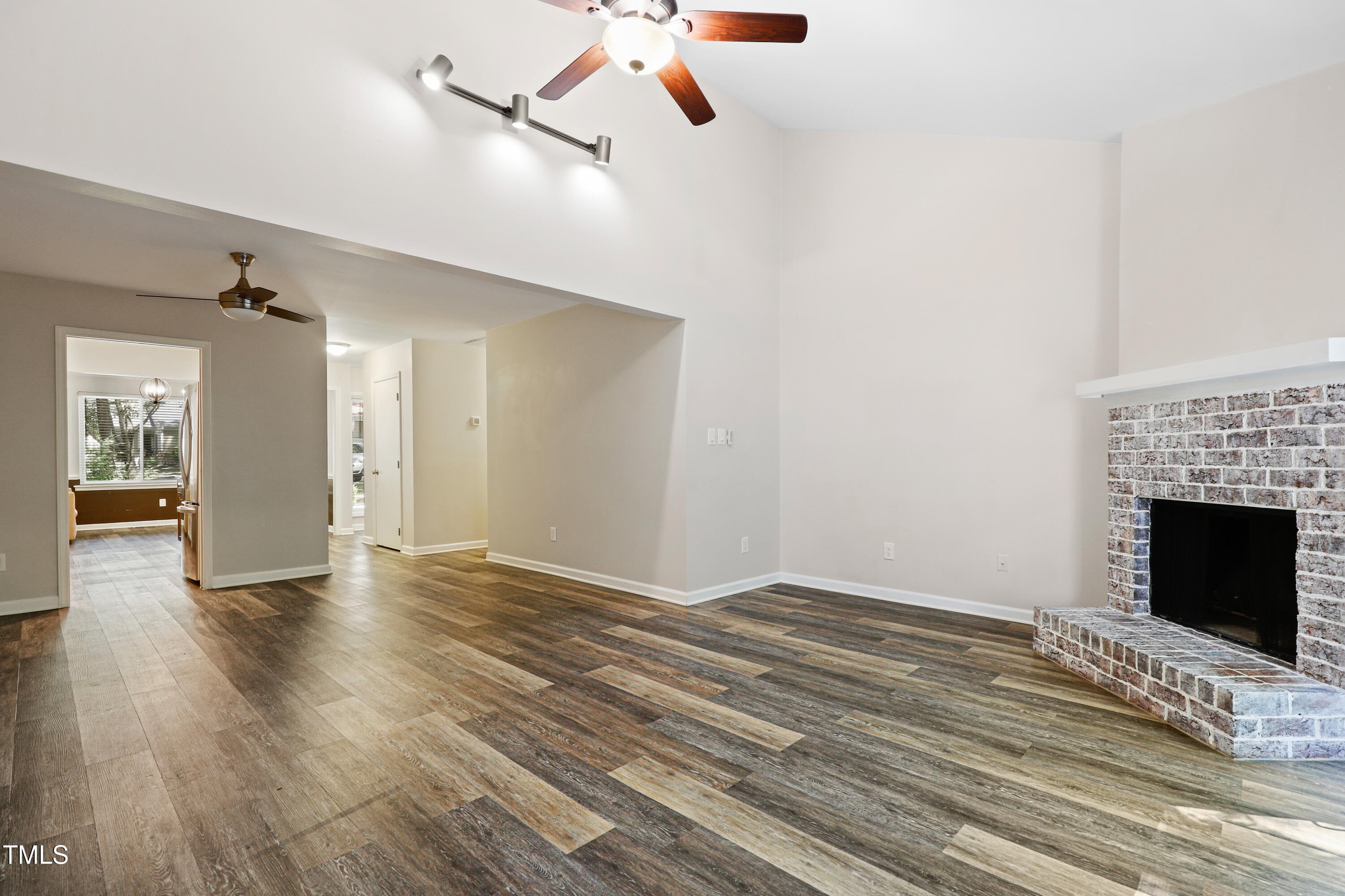 5840 Branchwood Road Raleigh, NC 27609 - Photo 6 of 33 a view of an empty room with wooden floor fireplace and a window