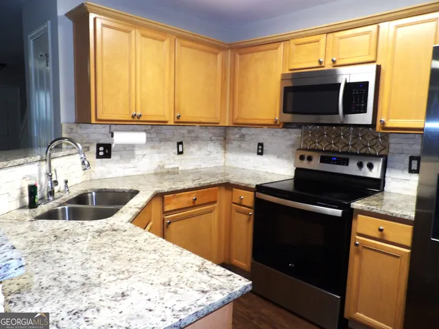 a kitchen with a sink stove and microwave