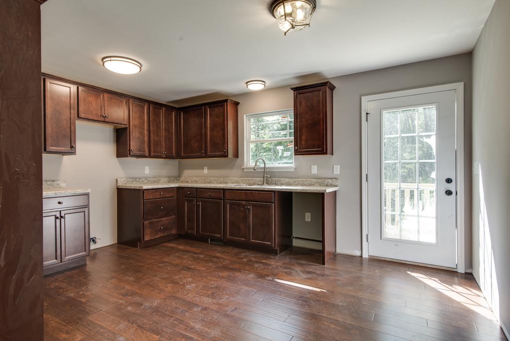 234 East Piney Road Dickson, TN 37055 - Photo 7 of 18 a kitchen with kitchen island granite countertop a stove top oven a sink and dishwasher a refrigerator with wooden floor