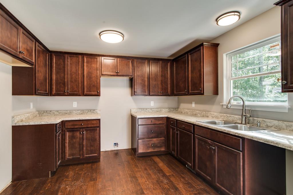 234 East Piney Road Dickson, TN 37055 - Photo 9 of 18 a kitchen with stainless steel appliances granite countertop wooden cabinets a sink and dishwasher with wooden floor