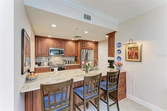 a large kitchen with stainless steel appliances granite countertop a sink stove and refrigerator