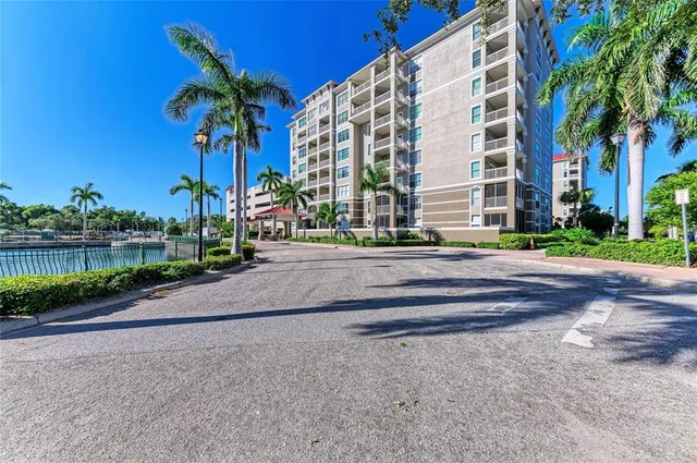 a view of a tall building with a yard and palm trees