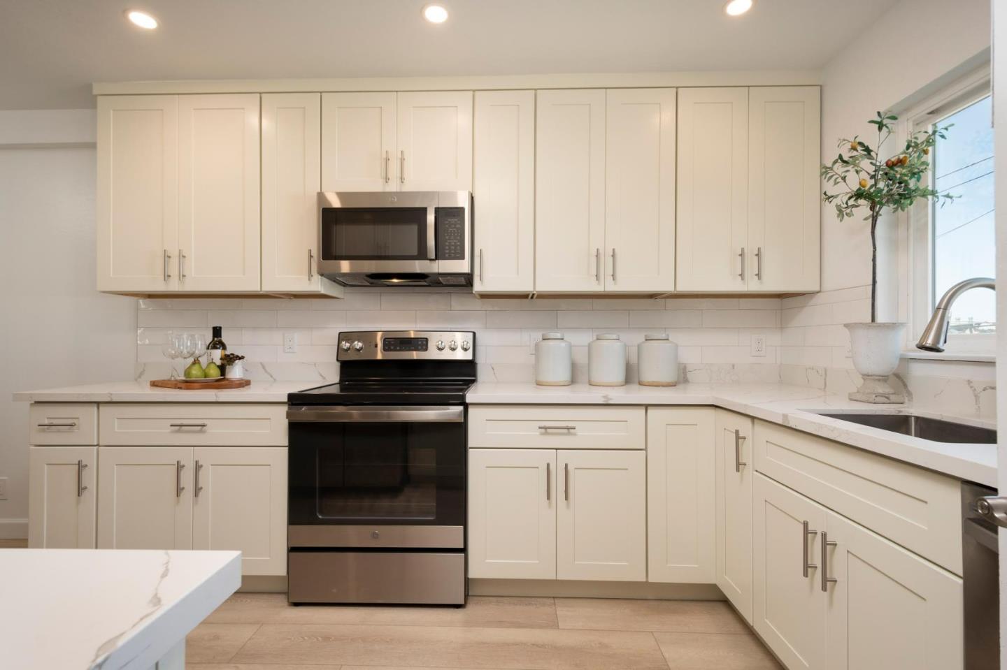 150 Surf Street Pacifica, CA 94044 - Photo 7 of 20 a kitchen with white cabinets and white appliances