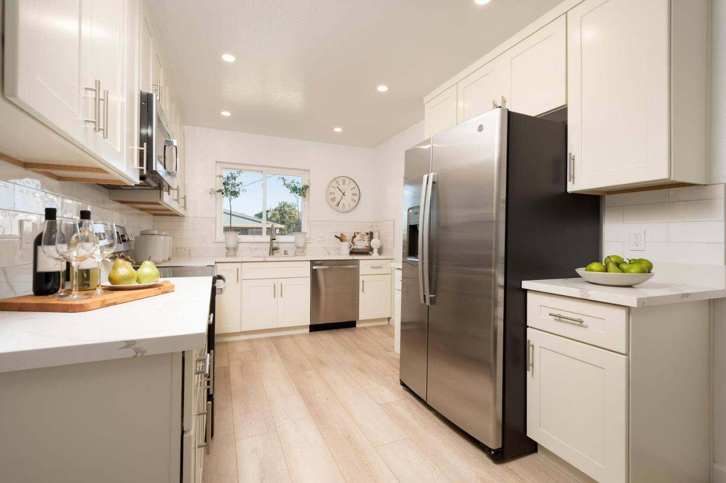 150 Surf Street Pacifica, CA 94044 - Photo 8 of 20 a kitchen with a sink stainless steel appliances and white cabinets