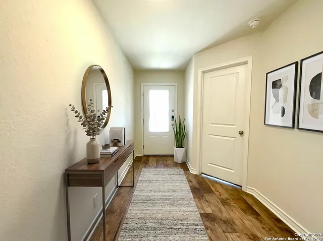a view of a hallway to a livingroom with furniture