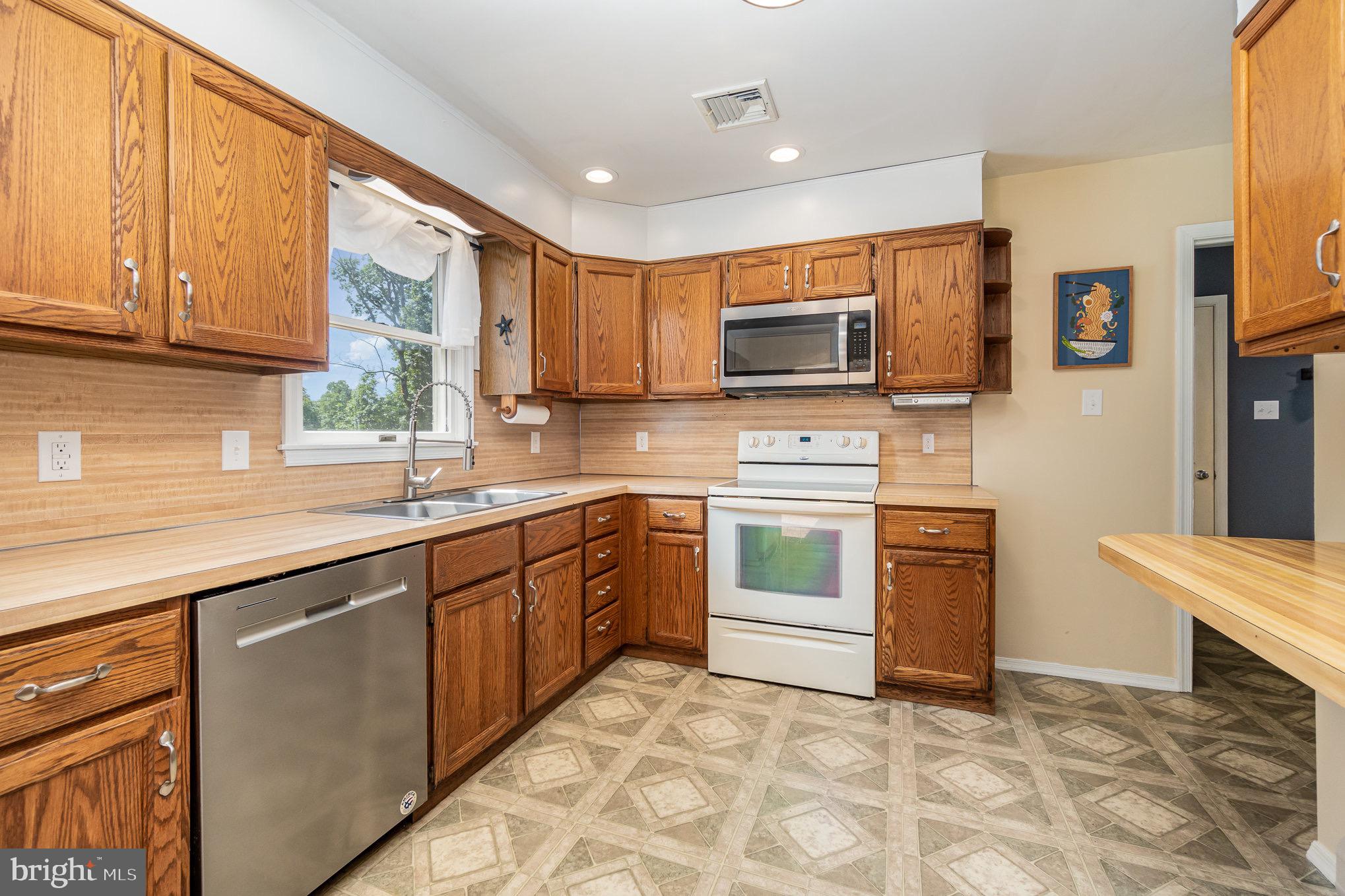 335 Apple Ridge Road Loysville, PA 17047 - Photo 9 of 46 a kitchen with stainless steel appliances granite countertop a stove top oven a sink dishwasher and a microwave oven on the blue kitchen countertops