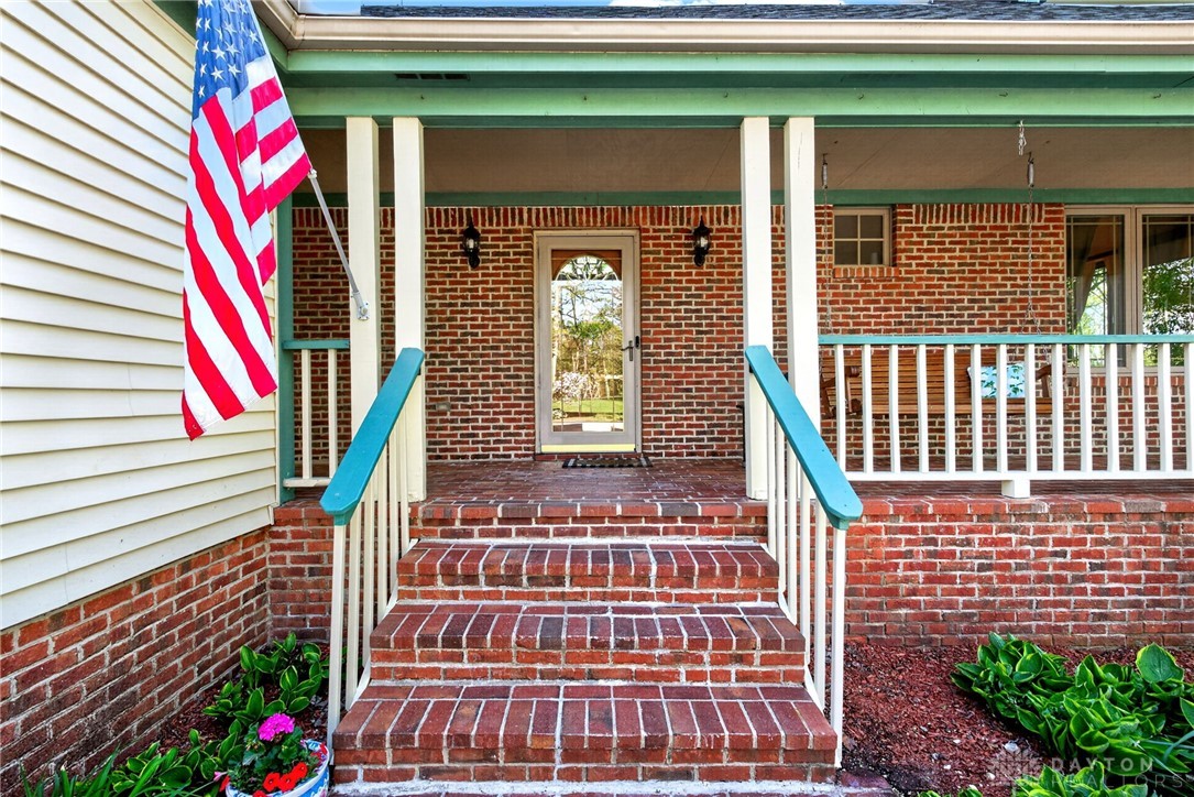 330 South Alpha Bellbrook Road Bellbrook, OH 45305 - Photo 6 of 87 Welcome to a charming brick home featuring a cozy porch, perfect for enjoying outdoor moments.