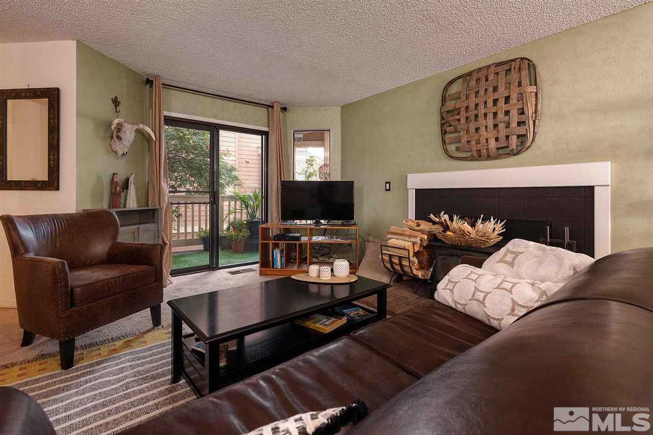 2875 Idlewild Drive, Unit 58 Reno, NV 89509 - Photo 5 of 25 a living room with furniture a flat screen tv and a fireplace