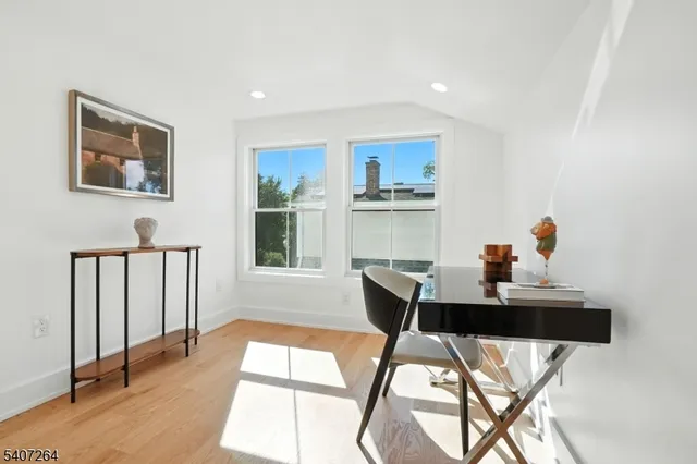 a view of a workspace with furniture and a window