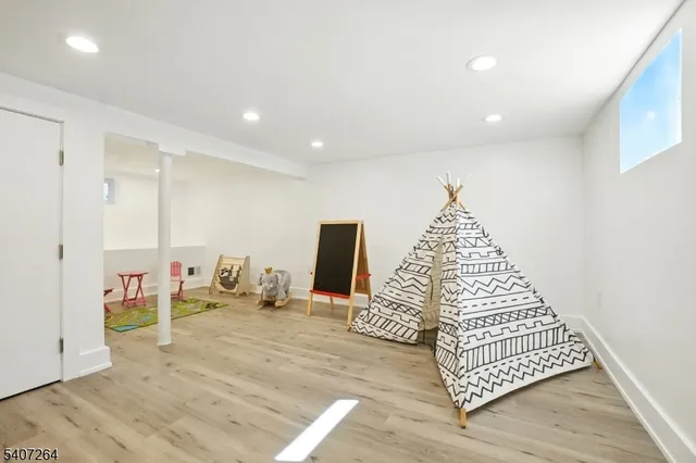 a view of an empty room with wooden floor and windows