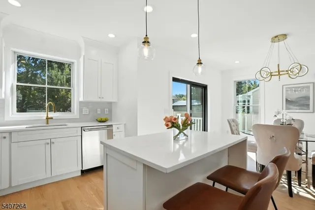 a kitchen with a sink a counter top space and living room view