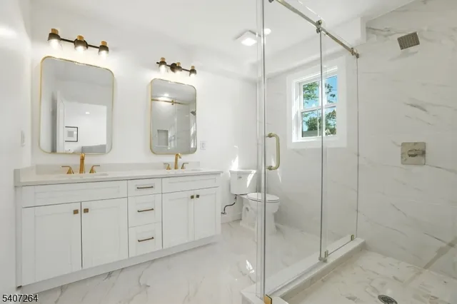 a bathroom with a double vanity sink mirror and shower