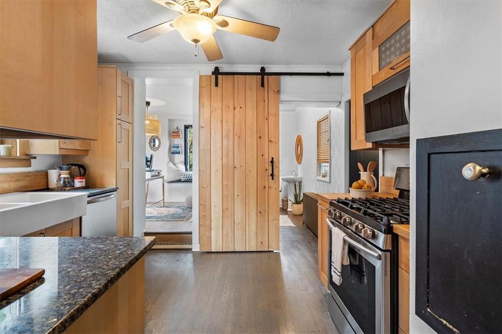 215 Elm Road Ambridge, PA 15003 - Photo 11 of 25 a kitchen with stainless steel appliances granite countertop a refrigerator a stove and a sink with wooden floor