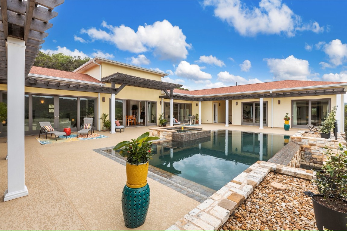 a view of a house with backyard swimming pool and sitting area