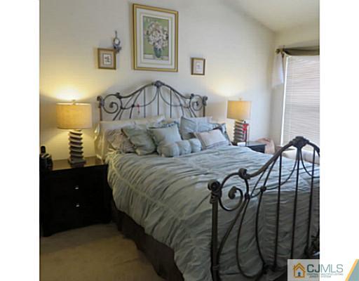 2403 Pheasant Run Monmouth Junction, NJ 08852 - Photo 6 of 10 a bedroom with a bed and a chandelier