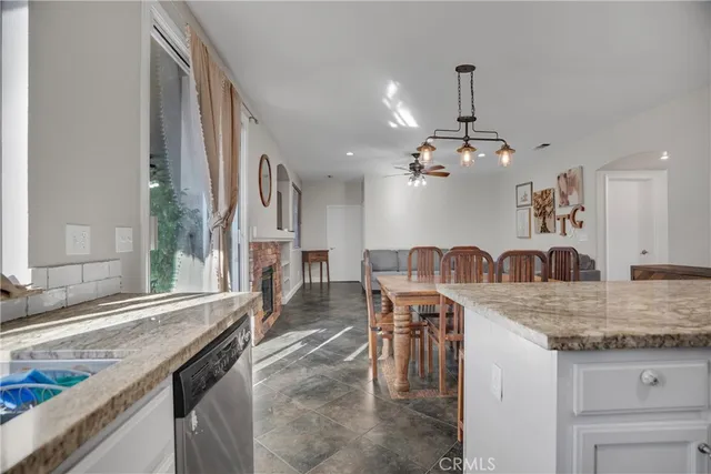 a kitchen with granite countertop a stove a sink a dining table and chairs