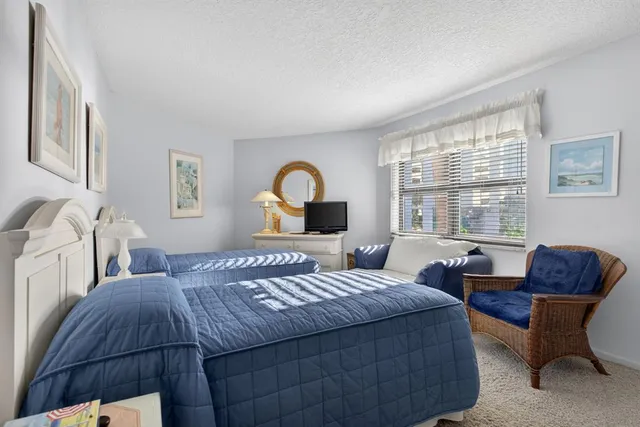 a bedroom with bed couch and window