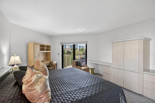 a spacious bedroom with a bed and glass walk in closet