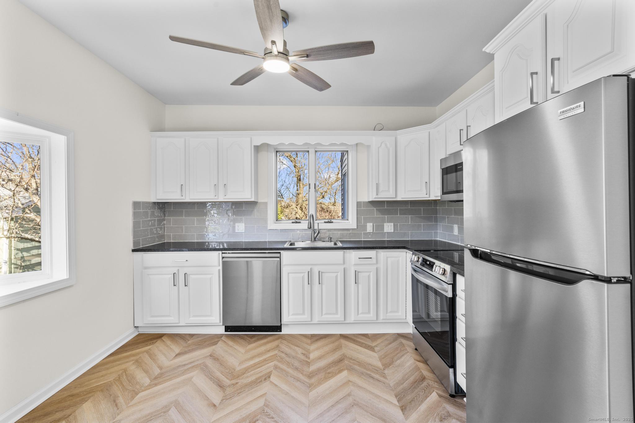 4 Bellview Road Branford, CT 06405 - Photo 11 of 30 a kitchen with granite countertop stainless steel appliances a refrigerator a sink a stove a microwave a center island and cabinets