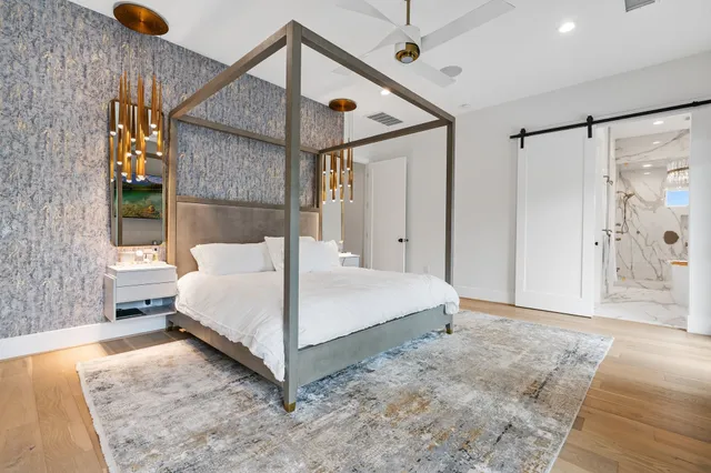 a bedroom with a bed and a flat tv screen on dresser