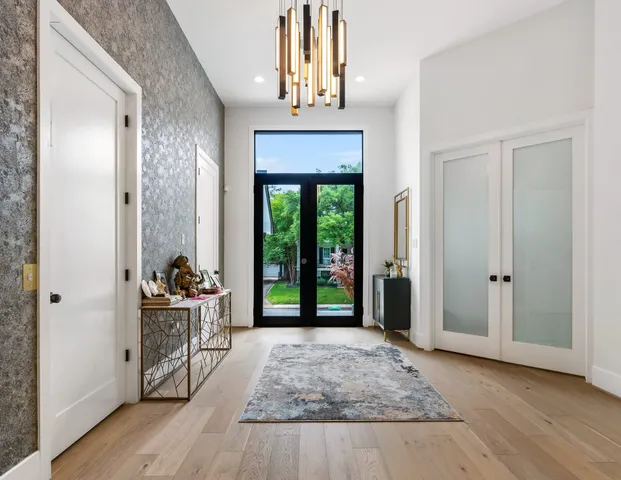 a view of a hallway with wooden floor and a chandelier