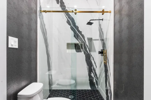 a bathroom with a toilet and a shower