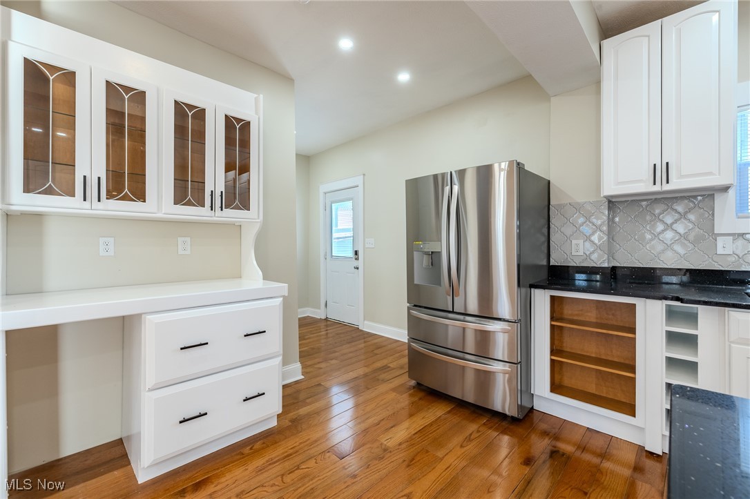 3516 Broadview Road Cleveland, OH 44109 - Photo 14 of 42 Kitchen with glass insert cabinets, stainless steel fridge with ice dispenser, decorative backsplash, hardwood / wood-style flooring, and white cabinetry