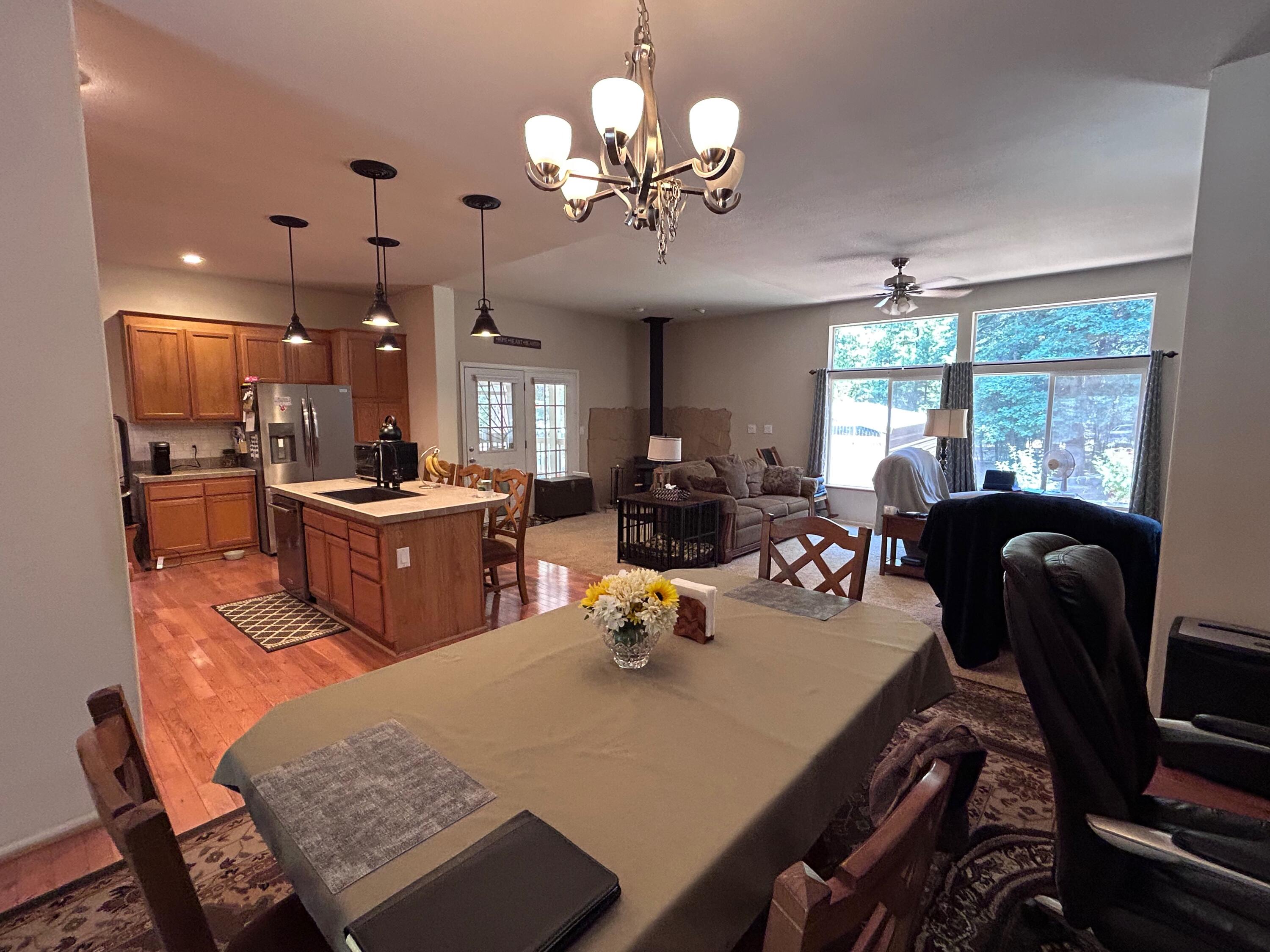 7150 Kaysie Rae Court Shingletown, CA 96088 - Photo 4 of 34 a view of a dining room with furniture a chandelier and large windows