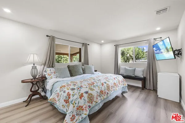 a bedroom with a bed a mirror and a large window