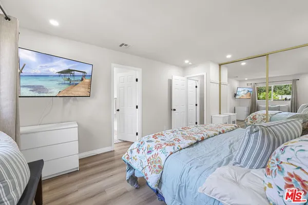 a bedroom with a bed and a painting on the wall