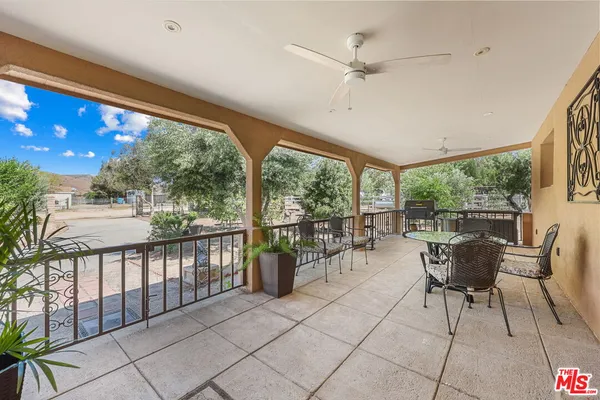 a view of a patio with chairs and table potted plants