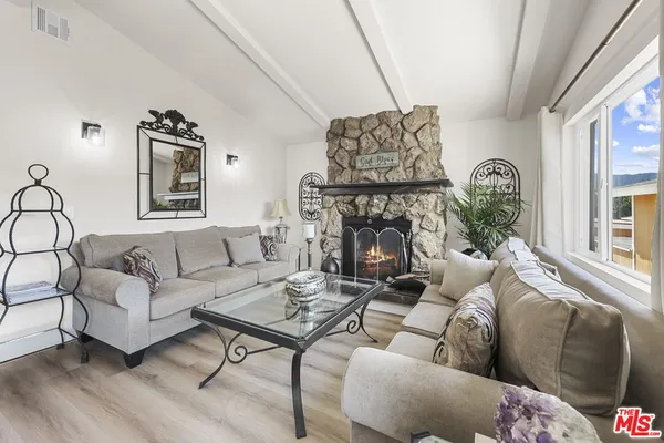 a living room with furniture a fireplace and a large window