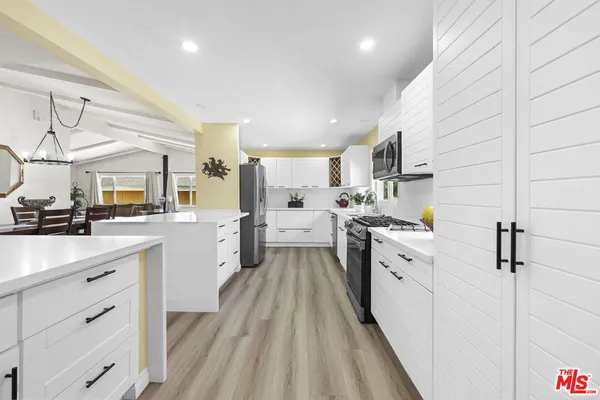 a kitchen with white cabinets appliances and sink