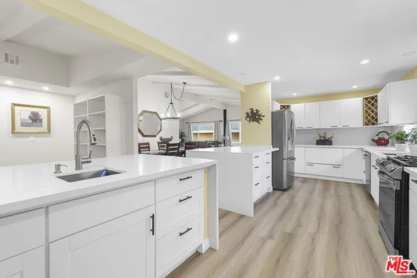 a kitchen with white cabinets and white appliances