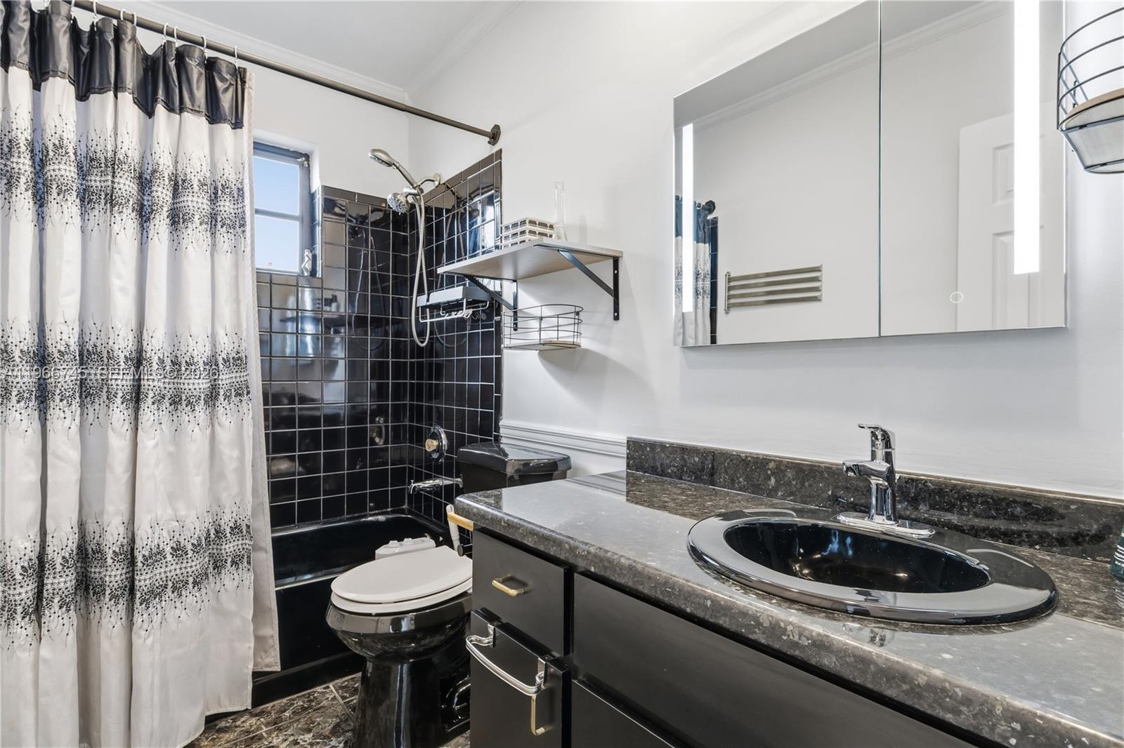 11753 Southwest 197th Street Miami, FL 33177 - Photo 26 of 36 a kitchen with a sink a toilet and shower curtain
