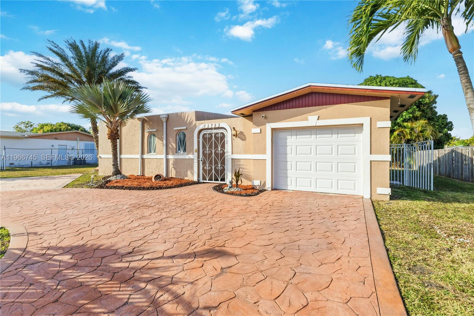 11753 Southwest 197th Street Miami, FL 33177 - Photo 32 of 36 a front view of a house with a yard and garage