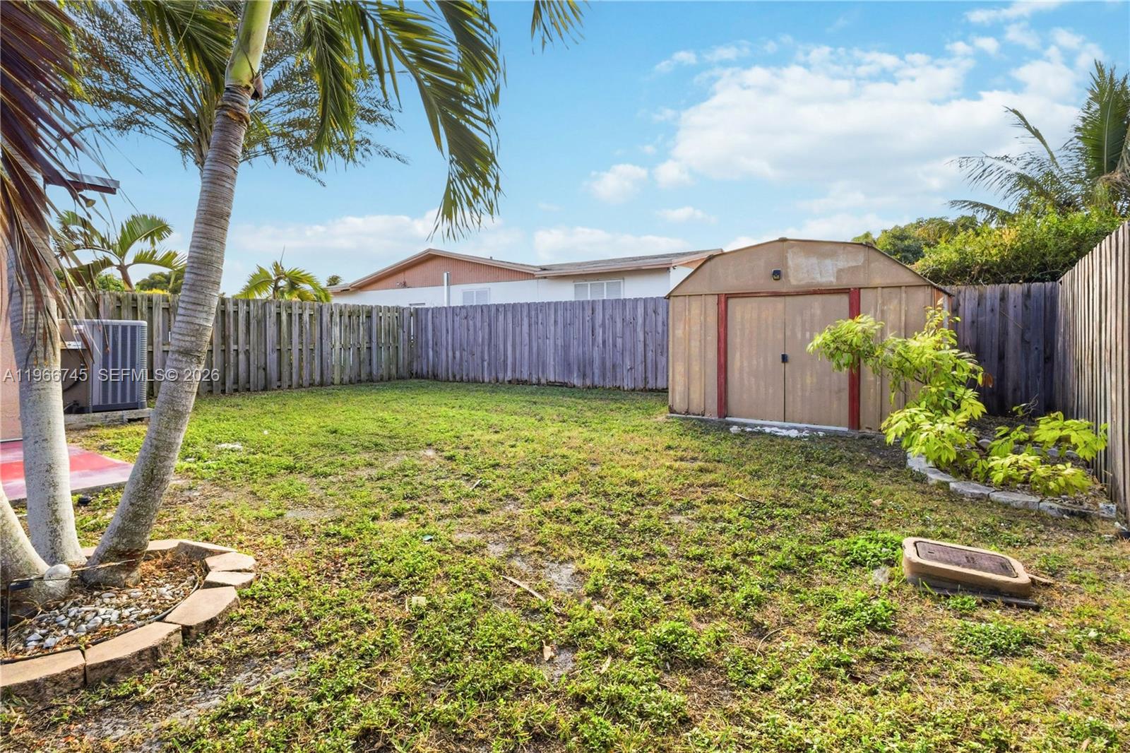 11753 Southwest 197th Street Miami, FL 33177 - Photo 34 of 36 a view of a backyard with potted plants and large tree