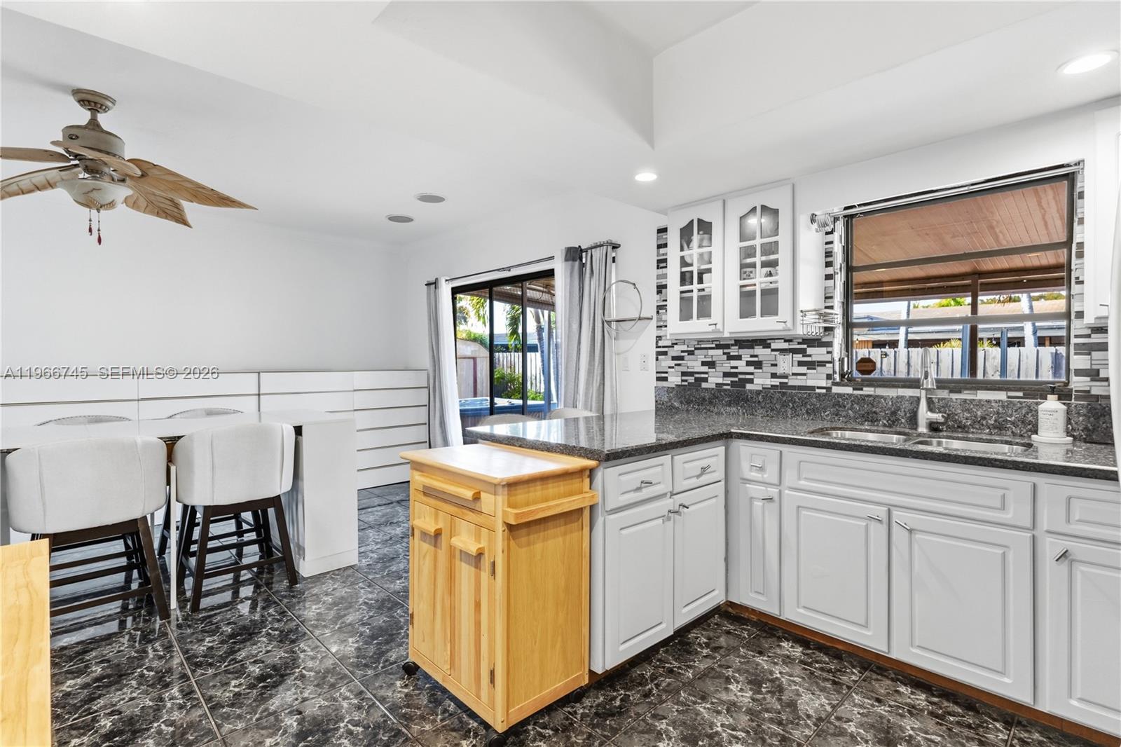 11753 Southwest 197th Street Miami, FL 33177 - Photo 7 of 36 a kitchen that has a sink and chairs in it