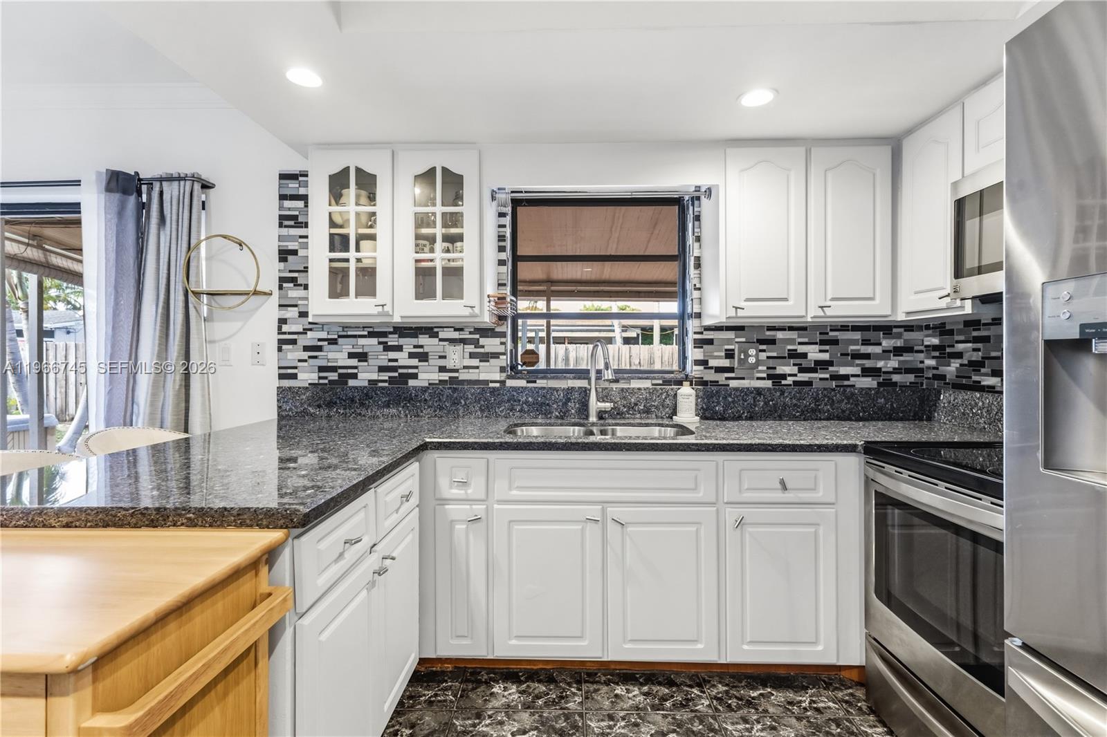11753 Southwest 197th Street Miami, FL 33177 - Photo 8 of 36 a kitchen with stainless steel appliances granite countertop a sink stove and cabinets