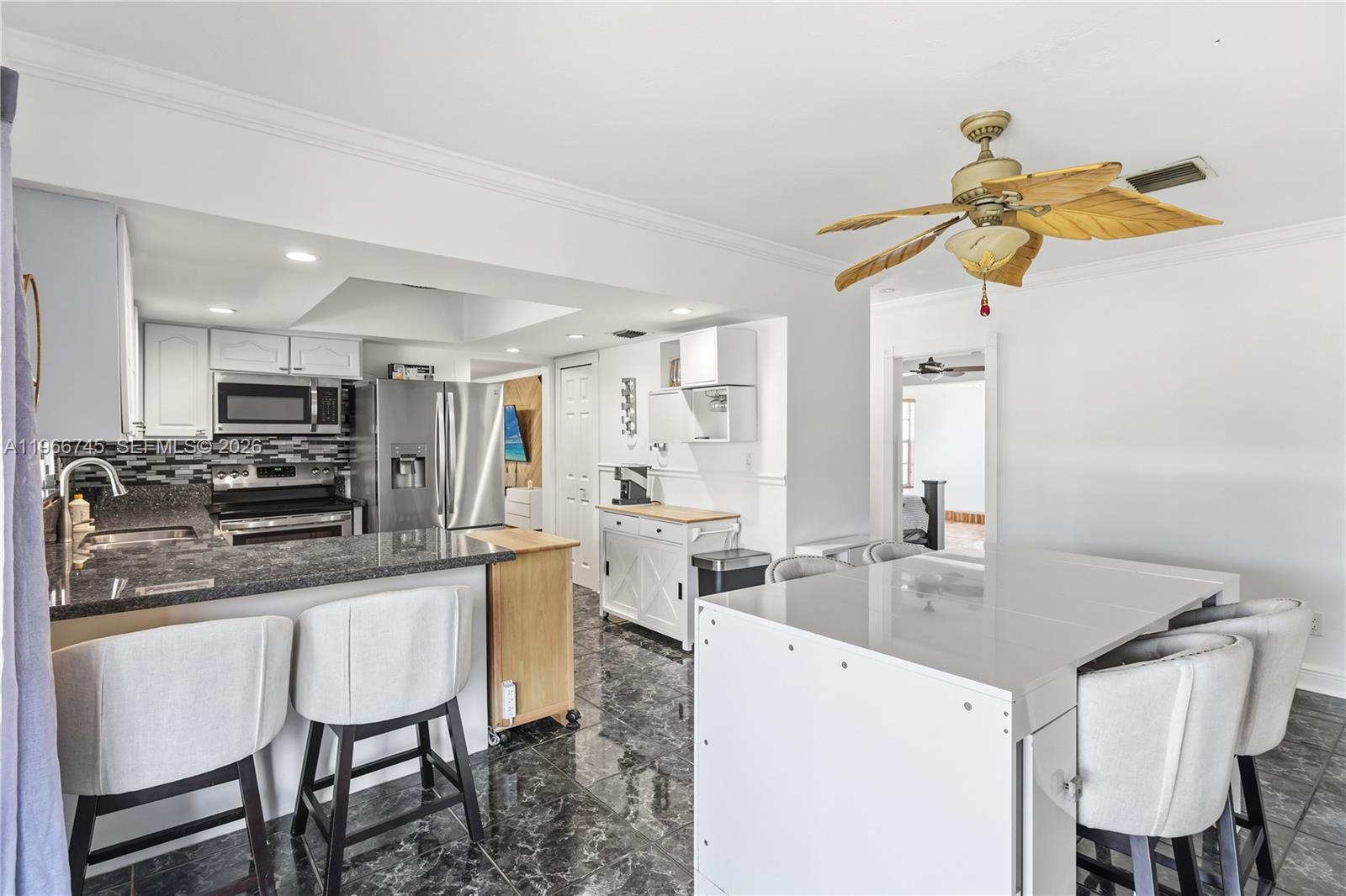 11753 Southwest 197th Street Miami, FL 33177 - Photo 10 of 36 a kitchen with a table chairs microwave and cabinets