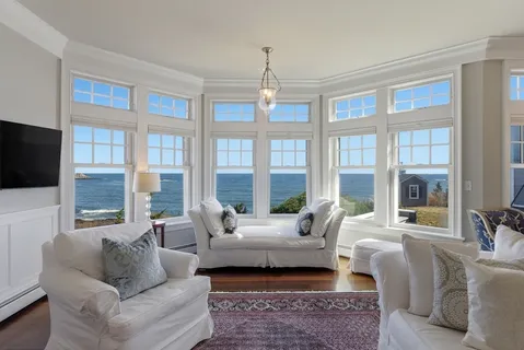a living room with furniture a flat screen tv and windows