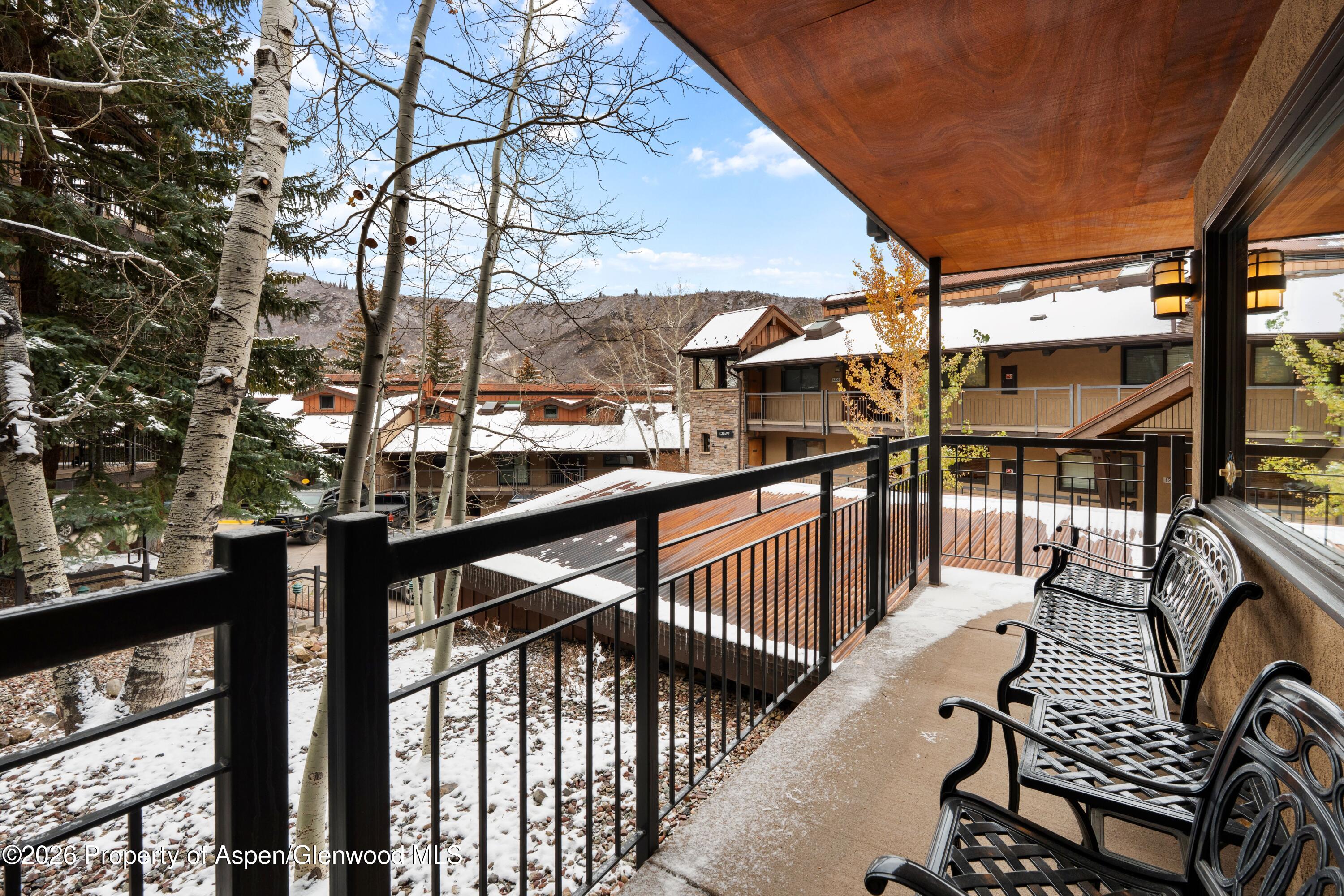 400 Wood Road, Unit 2111H Snowmass Village, CO 81615 - Photo 15 of 16 a view of balcony with wooden floor and fence