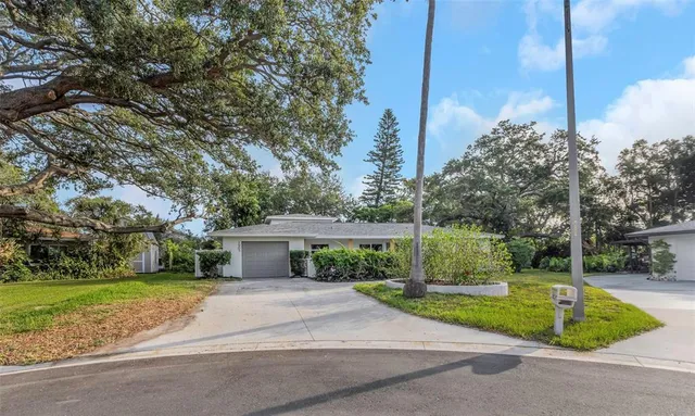 a view of a house with backyard and a tree
